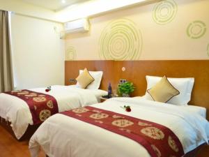 2 bedden in een hotelkamer met witte en rode lakens bij GreenTree Inn Ziyang Lezhi Government Tianchi Town Express Hotel in Ziyang