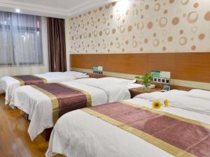 een hotelkamer met drie bedden in een kamer bij GreenTree Alliance Shandong Linyi Mengyin Xincheng road Hotel in Mengyin