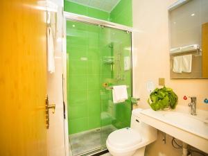 a bathroom with a shower and a toilet and a sink at GreenTree Inn Tangshan Qianxi Bus Terminal Express Hotel in Qian'an