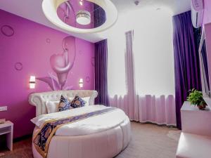 a pink bedroom with a bed with an octopus on the wall at Shell Hefei Changjiang West Road Nangang Subway Station Hotel in Hefei