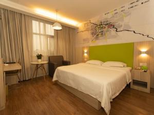 a bedroom with a large bed and a green wall at Vatica Bozhou City Railway Station Hotel in Bozhou