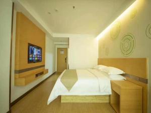 a bedroom with a large white bed and a television at GreenTree Inn Handan City Wu'an City Plaza Business Hotel in Handan +20 photos