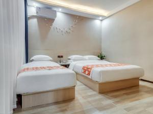 twee bedden in een hotelkamer met bij Shell Xi'an Yanta District Jixiang Village Subway Entrance Hotel in Xi'an