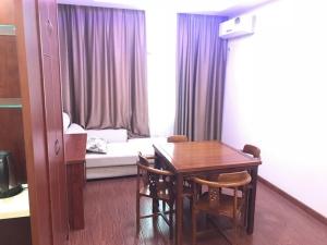 南通市にあるGreenTree Inn Nantong Liuqiao Town Government Tongliu Road Express Hotelのテーブル、椅子、ソファが備わる客室です。