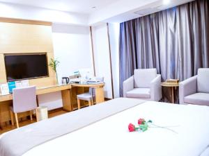a hotel room with a bed and a desk and chairs at GreenTree Inn Anhui Fuyang Yingshang Yingyang Road Suzhou Manor Business Hotel in Jingzhuang