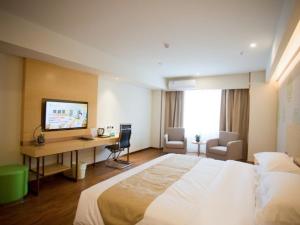 Habitación de hotel con cama grande y escritorio. en GreenTree Inn Jinan Tangye Express Hotel en Jinan