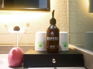 a bottle of honey sitting on a table with two cups at GreenTree Inn Fuyang Exhibition Center Business Hotel in Fuyang
