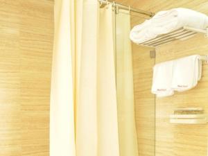 TianshuiにあるShell Tianshui Taian County Bus Station Hotelのシャワー(白いシャワーカーテン、タオル付)