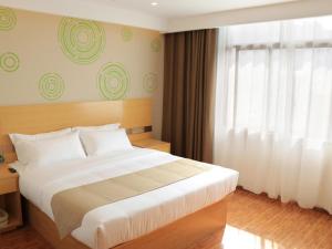 Un dormitorio con una cama grande y una ventana en GreenTree Inn Huangshi Huahu Development Zone Daquan Road Business Hotel en Huangshi