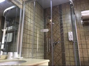een douche met een glazen deur in de badkamer bij GreenTree Inn Ziyang Lezhi Government Tianchi Town Express Hotel in Ziyang