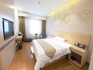 a hotel room with a large bed and a desk at GreenTree Inn Zhengzhou Fangte Green Expo Park Shangdu Road Express Hotel in Zhengzhou
