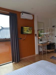 una camera con letto, scrivania e finestra di Twins Farm Resort a Mae Salong