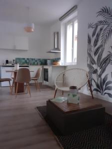 Il comprend une cuisine et un salon avec une table et des chaises. dans l'établissement Tropical loft, au Puy-en-Velay