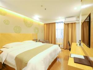 een hotelkamer met een groot bed en een televisie bij GreenTree Inn Yichun Development Zone Bus Terminal Express Hotel in Yichun