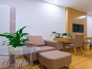 a living room with a couch and a table at GreenTree Inn Anshun Xihang Road Business Hotel in Anshun