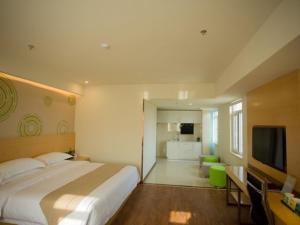 1 dormitorio con 1 cama grande y TV en GreenTree Inn Jinan Tangye Express Hotel en Jinan