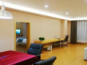 - une chambre avec un lit et un bureau dans l'établissement GreenTree Inn Yulin South Changcheng Road Business Hotel, à Yulin