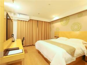 a hotel room with a large bed and a desk at GreenTree Inn Yichun Development Zone Bus Terminal Express Hotel in Yichun