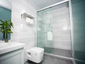 a bathroom with a toilet and a glass shower at Shell Chuzhou North Bus Station Hotel in Chuzhou