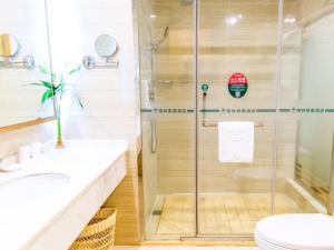 a bathroom with a glass shower and a toilet at GreenTree Inn Anhui Fuyang Yingshang Yingyang Road Suzhou Manor Business Hotel in Jingzhuang