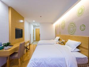 a bedroom with two beds and a desk and a tv at GreenTree Inn Anshun Xihang Road Business Hotel in Anshun +9 photos