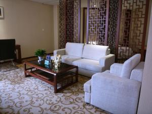 a living room with a couch and a coffee table at GreenTree Alliance Xuzhou Gulou District Sanhuan North Road, Jinju Wuliuwan Hotel in Xuzhou