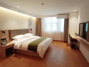 Un pat sau paturi într-o cameră la GreenTree Inn JiuJiang Railway Station Business Hotel