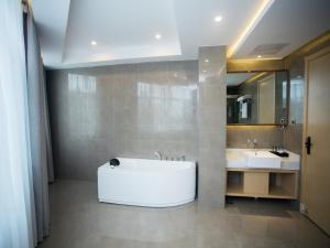 a large bathroom with a tub and two sinks at VX Heze Dingtao District Taoyi Road Hotel in Heze