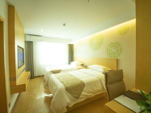 a hotel room with two beds and a window at GreenTree Inn Handan City Wu'an City Plaza Business Hotel in Handan