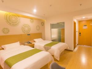 A bed or beds in a room at GreenTree Inn Suzhou Tai Lake Xukou Town Government Express Hotel