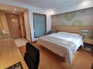 a bedroom with a large bed and a table at GreenTree Inn Bozhou Chunyu Motor City Express Hotel in Bozhou +28 photos