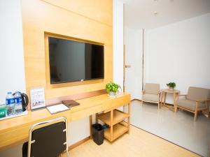 an office with a desk with a television on a wall at GreenTree Inn Tangshan Qianxi Bus Terminal Express Hotel in Qian'an
