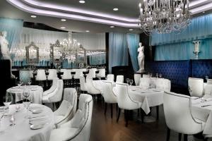 Sun City Hotel - The Gabriel في القاهرة: غرفة طعام مع طاولات بيضاء وكراسي بيضاء