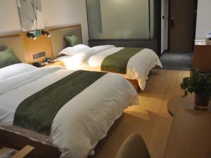twee grote bedden in een hotelkamer bij GreenTree Inn Shangqiu Zhecheng Shanghai Road in Shangqiu