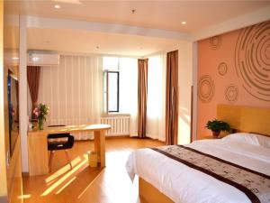 Cette chambre comprend un lit et un bureau. dans l'établissement GreenTree Inn Shenyang Shengjing Hospital Shenyang Liaol Road Business Hotel, à Shenyang