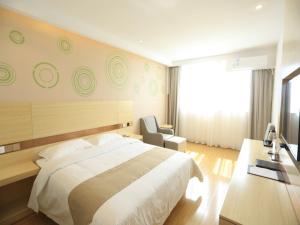 a bedroom with a bed and a desk and a chair at GreenTree Inn Anqing City Yixiu Government District University City Express Hotel in Anqing +8 photos