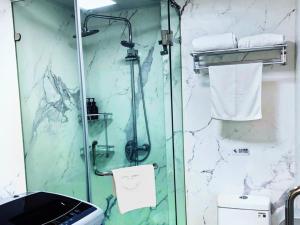 a shower with a glass door in a bathroom at GreenTree Shanghai Zhongshan North Road Apartment Hotel in Shanghai