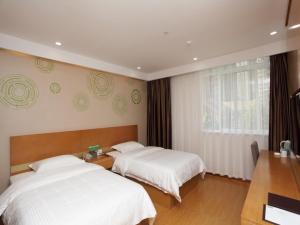um quarto com 2 camas e uma janela em GreenTree Inn Hefei Huainan Road Huaihe Garden Express Hotel em Hefei