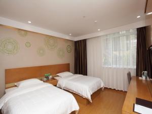 a bedroom with two beds and a window at GreenTree Inn Hefei Huainan Road Huaihe Garden Express Hotel in Hefei