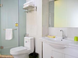 a white bathroom with a toilet and a sink at Shell Taiyuan Xiaodian District Shanxi Hospital Hotel in Taiyuan