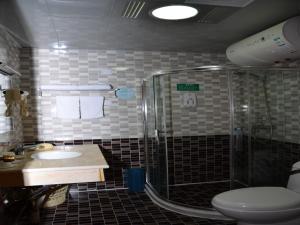 a bathroom with a shower and a toilet and a sink at GreenTree Inn Huangshan City Huangshan Scenic Area North Gate Express Hotel in Huangshan