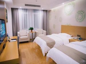 a hotel room with two beds and a flat screen tv at GreenTree Inn Jinan Jiyang Bus Station Express Hotel in Jiyang