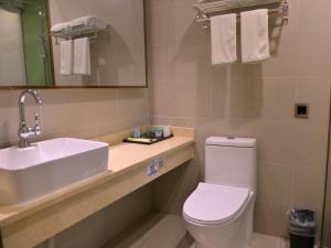 a bathroom with a white toilet and a sink at GreenTree Inn LuoYang Ruyang County Dujuan Avenue Hotel in Ruyang