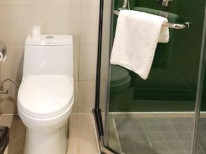 W łazience znajduje się toaleta i przeszklony prysznic. w obiekcie Vatica Fuyang Linquan County Tenghui International City Hotel w Fuyang