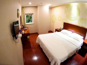 a bedroom with a white bed and a television at GreenTree Inn Jiangsu Suqian Xiangwang Guli South Xingfu Road Business Hotel in Suqian +39 photos