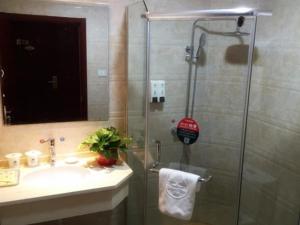 a bathroom with a shower with a sink and a shower at GreenTree Inn Nantong Liuqiao Town Government Tongliu Road Express Hotel in Nantong