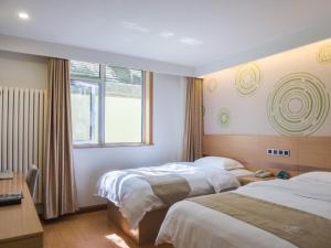 Habitación de hotel con 2 camas y ventana en GreenTree Inn Beijing Dongcheng District Wangfujin South Luogu Lane Houhai Express Hotel, en Beijing
