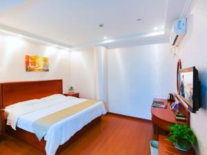 a bedroom with a bed and a desk and a television at GreenTree Inn Zhejiang Shaoxing Paojiang Industrial Park Tanggong Road Business Hotel in Shaoxing