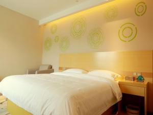 una camera con un grande letto bianco e una scrivania di GreenTree Inn Suzhou Yongqiao District Suma Park Suzhou Avenue High-speed Railway Station Business Hotel a Suzhou