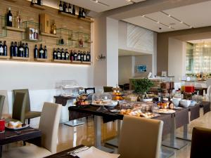 a restaurant with a long table with food and wine bottles at Partenope Relais in Naples